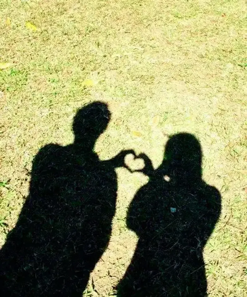 Sombras de pareja formando un corazón unidas por energía espiritual