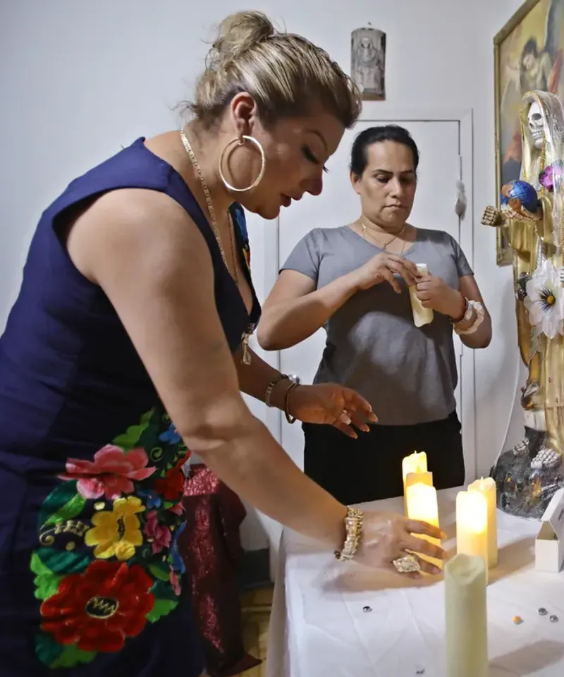 Mujeres preparando altar de Santa Muerte durante consulta espiritual